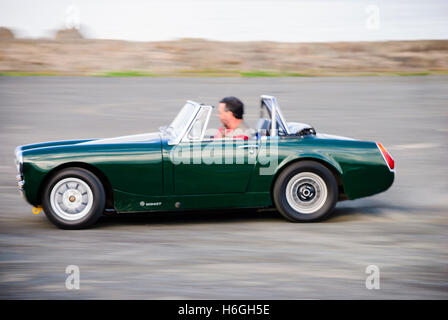 Green MG Midget driven at speed. Stock Photo