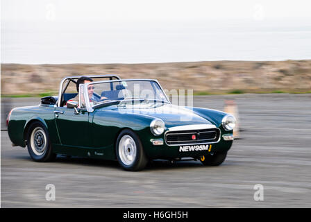 Green MG Midget driven at speed. Stock Photo