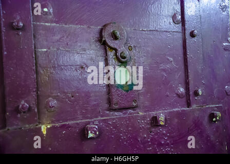 Peephole on a purple prison cell door Stock Photo