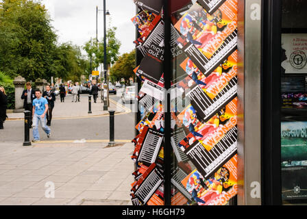 Nightclub invitations and advertising sticking out from doors in BT Telephone Boxes in the student area of Belfast. Stock Photo