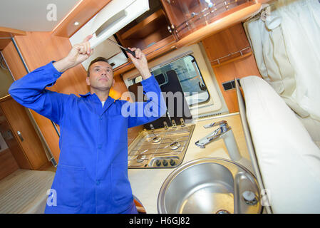 Mechanic working on interior of camper van Stock Photo