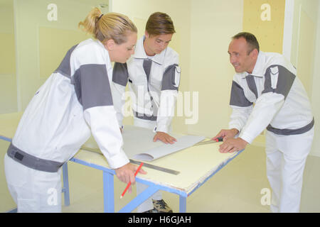 Team of decorators in discussion around a table Stock Photo