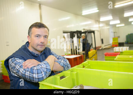 Portrait of man leaning on crate of fish Stock Photo