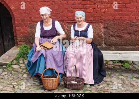 Two ladies dressed in traditional costume carding and knitting, Den Gamle By, Aarhus, Denmark Stock Photo