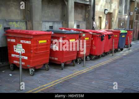 line old red dumpsters rubbish bins in alley yellow lines Stock Photo
