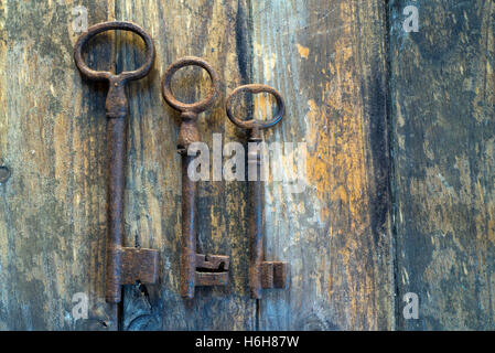 Three old keys on wooden table Stock Photo