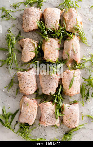 Raw chicken thighs with tarragon and spices ready to cook for dinner Stock Photo