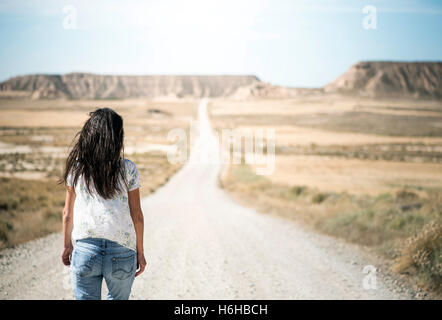 Woman walking on dirt road. Looking like a movie Stock Photo