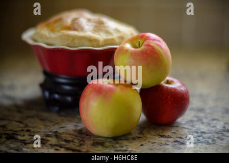 Apples with a apple pie on a kitchen counter. Stock Photo