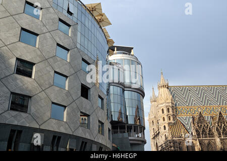 Controversial contrast of postmodernist Haas-Haus building and gothic St. Stephen's Cathedral, Stephansdom, Vienna, Austria Stock Photo