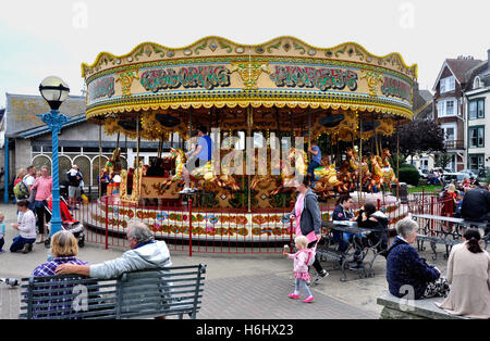 Dorset - Weymouth sea front fairground scene - galloping horses carousel - visitors having fun - colour and movement - holidays Stock Photo