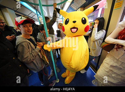 London, UK. 29th October 2016. Pikachu from Pokemon, aka 12 year old John from London, rides the DLR, Dockland Light Railway, to day two of MCM London Comic Con, one of the largest pop culture events in the UK taking place at Excel London. Credit:  Paul Brown/Alamy Live News
