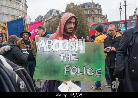 London, UK. 29th October 2016. A man holds a poster 'Abolish the Police' as he waits to march with the Families and friends of people killed by police or in prisons. Peter Marshall/Alamy Live News
