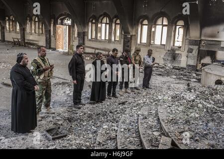 October 29, 2016 - Al Hamdaniyah, Nineveh Governorate, Iraq - Soldiers, residents and priests pray in front of the alter in ruins of Al Hamdaniya Church. The church had been used for a hideout for Islamic State fighters. (Credit Image: © Berci Feher via ZUMA Wire) Stock Photo