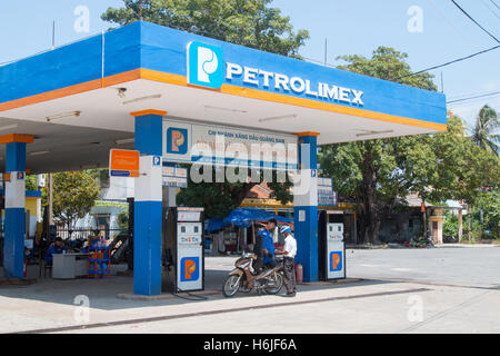 Attendant putting fuel gas in scooter motorbike at a Vietnamese petrol station Petrolimex , Vietnam Stock Photo