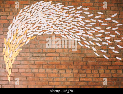 background with a brick wall. the flying feathers on a brick wal Stock Photo
