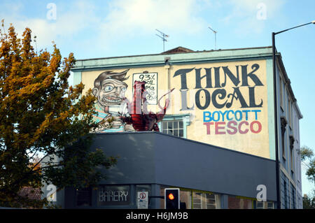 'Think local - boycott Tesco' graffiti on a wall of a house in Stokes Croft, Bristol, England, UK Stock Photo