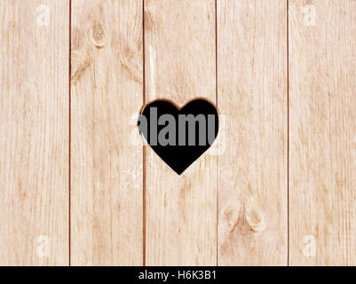 Heart shape cut on wooden wall, toilet, wc door or window Stock Photo