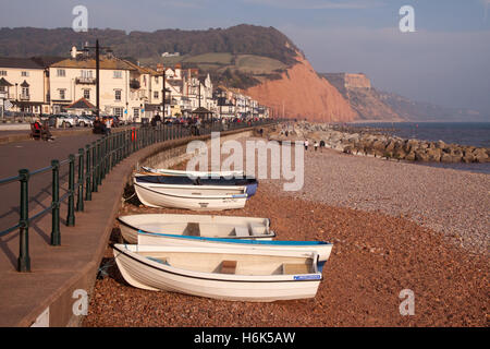 Sidmouth. Boats on the beach at Sidmouth, Devon,with the regency fronted seaside town behind Stock Photo