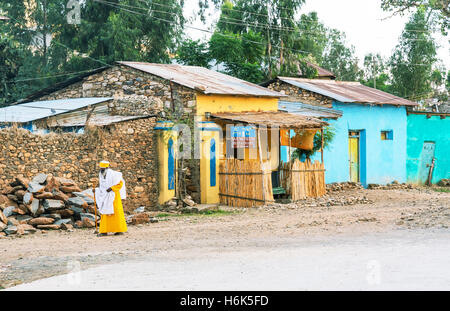 Axum, Ethiopia - January 20 , 2016:  A priest in front of the poor houses of the outskirts Stock Photo