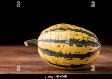 small decorative pumpkin on wood and black background Stock Photo