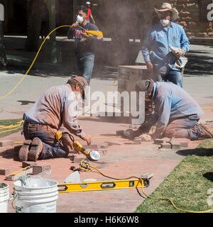 Tucson, Arizona - Bricklayers at the University of Arizona building a full-size outline of the U.S.S. Arizona battleship. Stock Photo