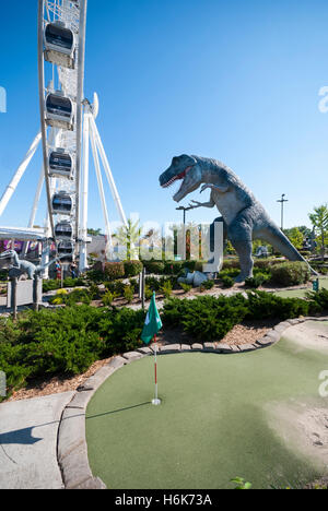 The Skywheel seen next to Dinosaur Adventure Golf a 70,000 sq foot dinosaur themed mini golf attraction in Niagara Falls Canada Stock Photo