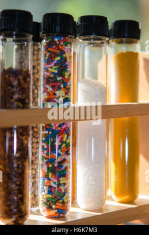 spices and sugar sprinkles in test tubes with lit background Stock Photo