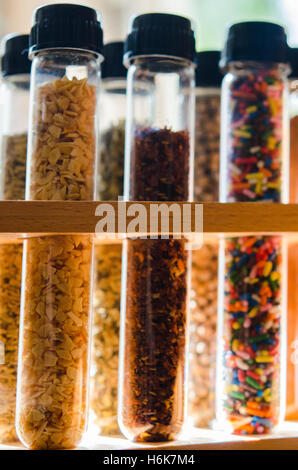 spices and sugar sprinkles in test tubes with lit background Stock Photo