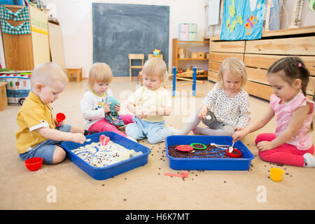 Children improving hands motor skills with rice and beans Stock Photo