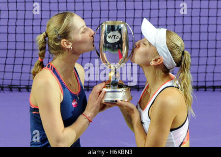 Singapore. 30th Oct, 2016. Ekaterina Makarova (L) and Elena Vesnina of Russia kiss the trophy after winning their WTA Finals match against Bethanie Mattek-Sands of Romania and Lucie Safarova of the Czech Republic at Singapore Indoor Stadium, Oct. 30, 2016. Ekaterina Makarova and Elena Vesnina won 2-0. © Then Chih Wey/Xinhua/Alamy Live News Stock Photo