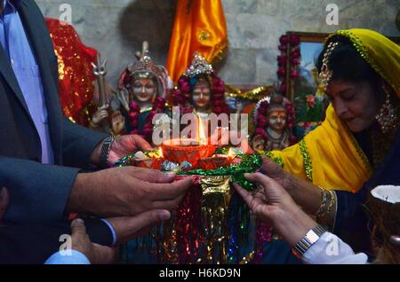 Lahore, Festival of Lights. 30th Oct, 2016. Members of a Pakistani Hindu family pray to mark Diwali, the Festival of Lights, in eastern Pakistan's Lahore on Oct. 30, 2016. The Hindu festival of lights, Diwali, marks the homecoming of the God Lord Ram after vanquishing the demon king Ravana and symbolises taking people from darkness to light and the victory of good over evil. © Jamil Ahmed/Xinhua/Alamy Live News Stock Photo