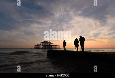 Brighton Sussex UK 30th October 2016 - Visitors enjoy the beautiful sunset at another extra Autumn low tide by the West Pier in Brighton at dusk this evening as the unusually mild weather continues in the south of the UK  Credit:  Simon Dack/Alamy Live News Stock Photo