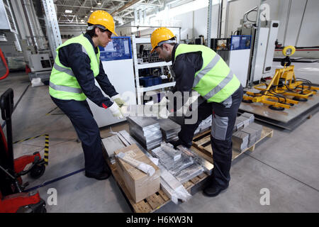 Workers taking aluminium billet at CNC machine shop Stock Photo