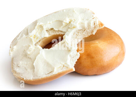 Plain bagel spread with cream cheese and bite missing. Isolated. Stock Photo