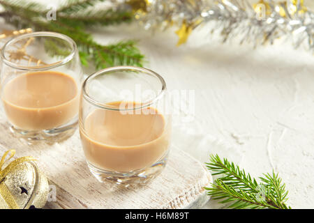 Irish cream coffee liqueur, Christmas decoration and ornaments over white background - homemade festive Christmas alcoholic Stock Photo