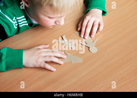 Confused child with broken paper family, custody, family problems, divorce, suffer concept Stock Photo