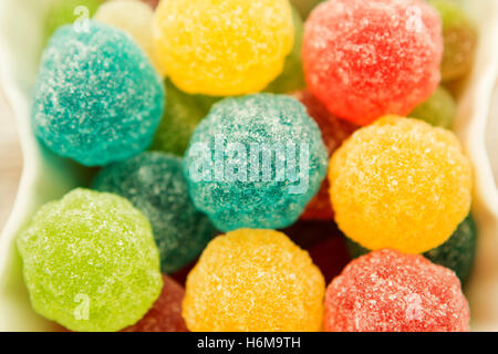 Colorful jelly beans of different sizes close to wallpaper Stock Photo