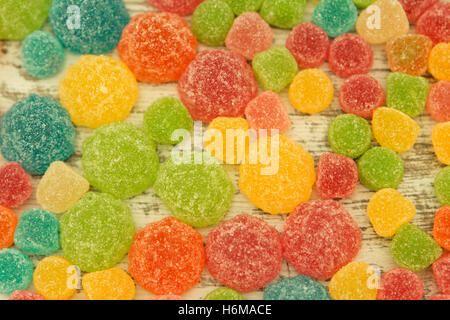 Colorful jelly beans of different sizes close to wallpaper Stock Photo