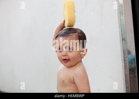 Funny kid showering in the yard for a summer afternoon Stock Photo