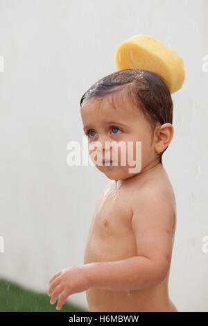 Funny kid showering in the yard for a summer afternoon Stock Photo
