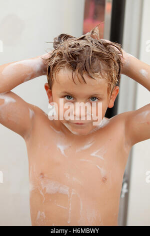 Funny kid showering in the yard for a summer afternoon Stock Photo