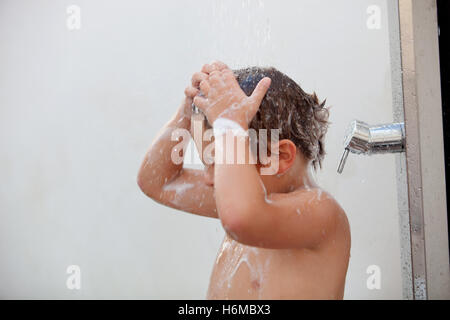 Funny kid showering in the yard for a summer afternoon Stock Photo