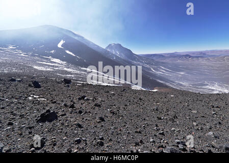 View from the top of a high mountain with volcanoes on the front left and the valley right down bellow. Stock Photo