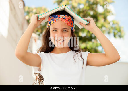 Pretty Twelve Year Old Student with a book outdoor Stock Photo