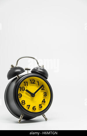 Black vintage retro style alarm clock on white background and selective focus Stock Photo