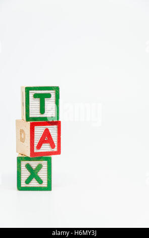 TAX word wooden block arrange in vertical style on white background and selective focus