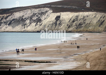 Compton Bay and Freshwater Cliff on the Isle of Wight with small figures taking a weekend walk at low tide. Stock Photo
