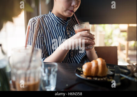 Weekend afternoon lifestyle and activity of young hipster woman holding and drinking iced chocolate in cafe. Sunday morning life Stock Photo