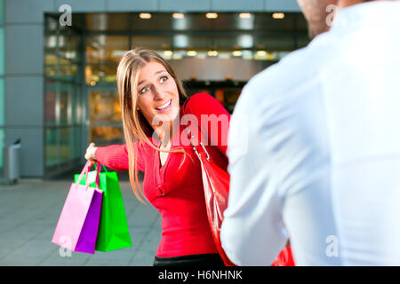 woman pulling man in shopping center Stock Photo